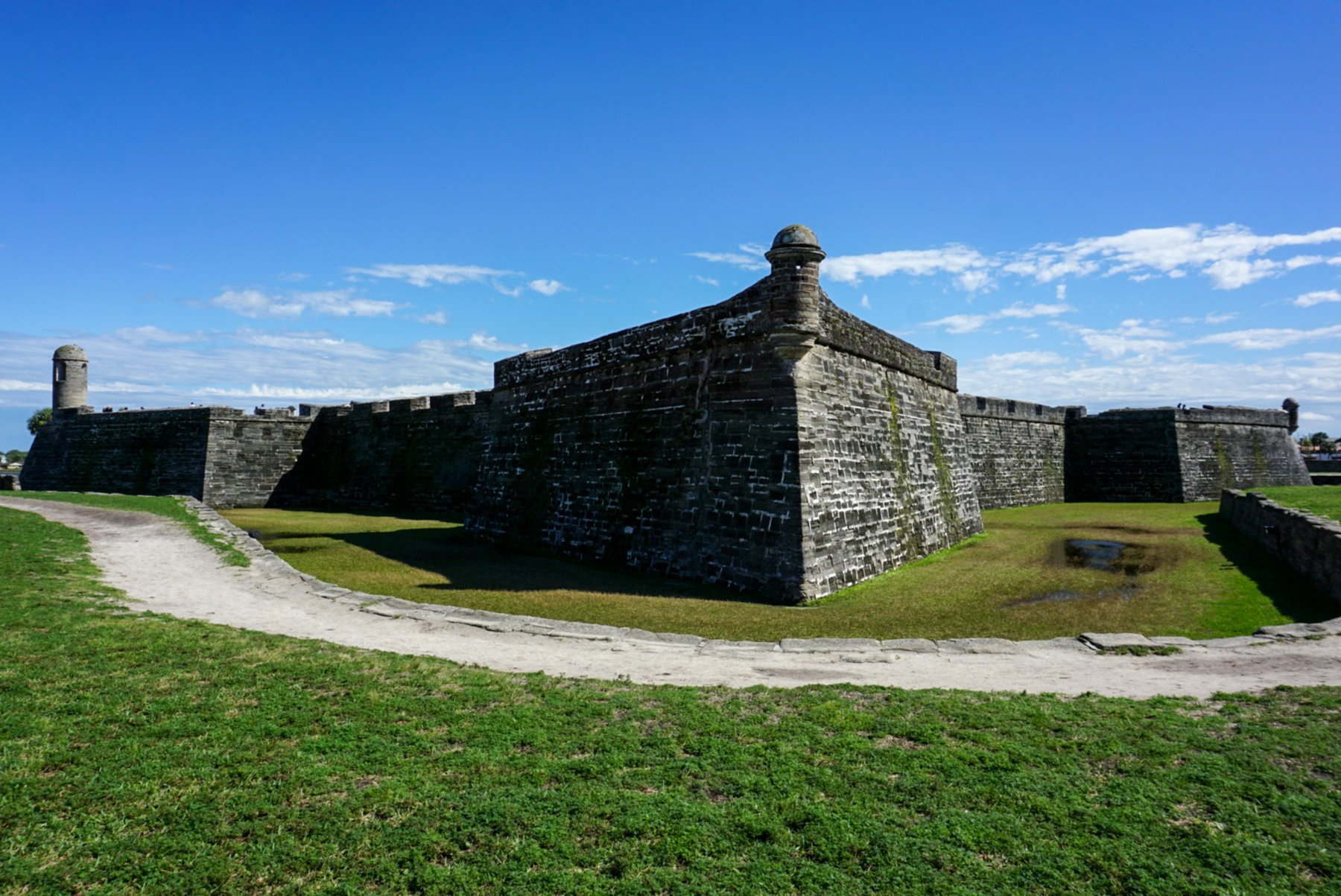 The coquina walls of the Castillo de San Marcos under a blue sky in St. Augustine